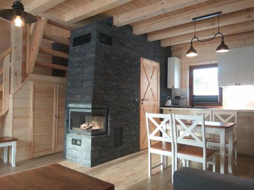 a kitchen and living room with a stone fireplace at Domek Przy Stoku in Tylicz