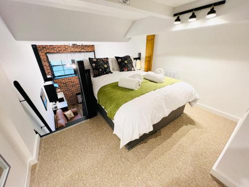 een slaapkamer met een bed met een groene deken bij Apartment 7 Sullivan House in Hereford