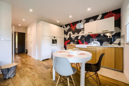 eine Küche und ein Esszimmer mit einem weißen Tisch und Stühlen in der Unterkunft Wellness Apartamenty Złoty Widok in Szczyrk