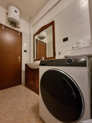 a bathroom with a sink and a washing machine at Apt by Trieste University in Trieste