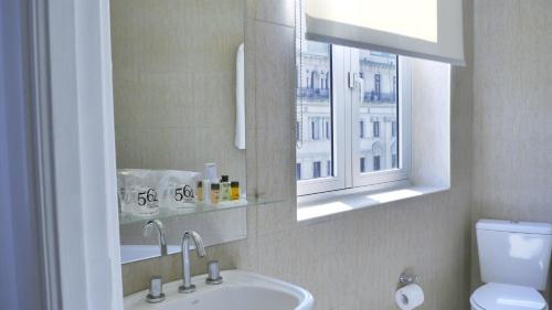 baño con lavabo, espejo y ventana en 562 Nogaro en Buenos Aires