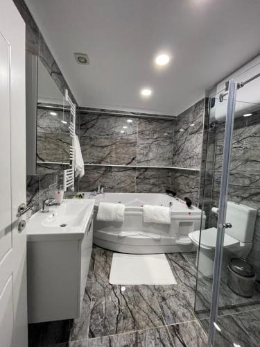 a bathroom with a tub and a sink at Suite In City Center in Tirana