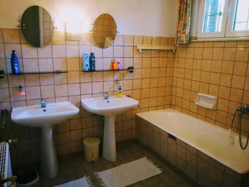 a bathroom with two sinks and a bath tub at De Nachtegaal in Eláfion
