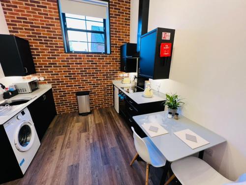 a small kitchen with a table and a washing machine at Apartment 8 Sullivan House in Hereford