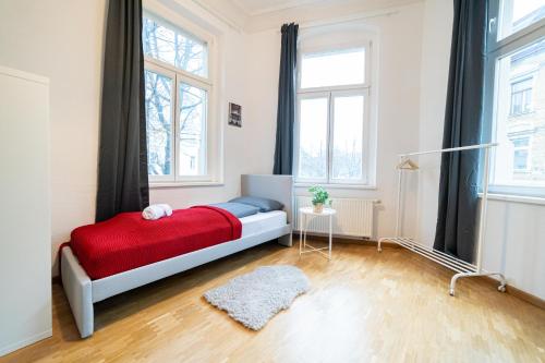 ein Schlafzimmer mit einem Bett mit einer roten Decke in der Unterkunft FULL HOUSE Premium Apartments Halle VS7 in Halle an der Saale