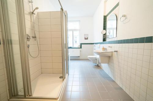 ein Bad mit einer Dusche und einem Waschbecken in der Unterkunft FULL HOUSE Premium Apartments Halle VS7 in Halle an der Saale