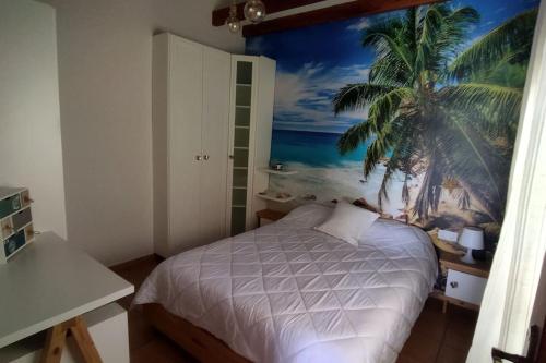 um quarto com uma cama com um mural de palmeira em Penthouse next to the beach em La Jaca