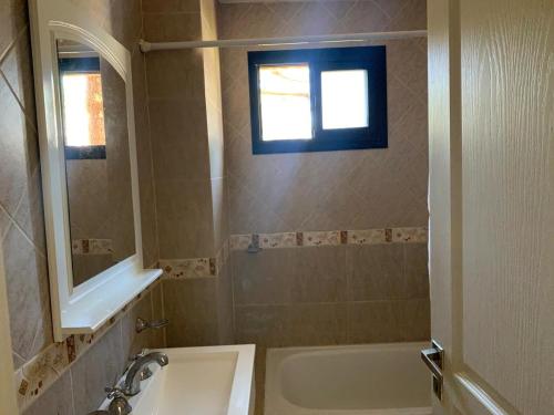 baño con lavabo, bañera y ventana en Complejo Playa Palace The Residence en Costa del Este