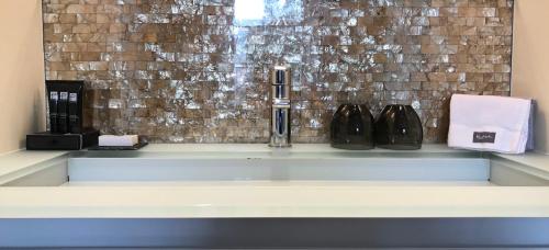 a bathroom sink with two black bottles on a counter at Boutique Hotel Straelman in Nijmegen