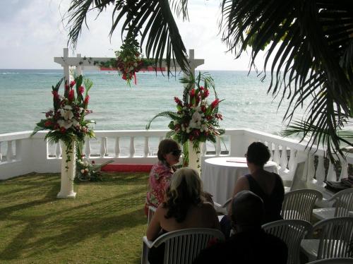 a group of people sitting at a wedding on the beach at Whispering Bamboo Cove Resort in Belfast