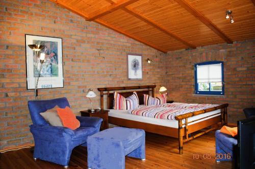 ein Schlafzimmer mit einem Bett und zwei blauen Stühlen in der Unterkunft Blankenese in Ahlbeck