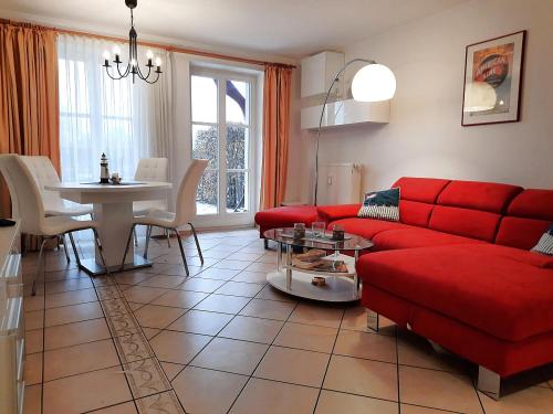 ein Wohnzimmer mit einem roten Sofa und einem Tisch in der Unterkunft Vineta App. 01 in Bansin