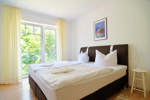 a large bed in a room with a large window at Wilhelmstr-10-Whg-25 in Ahlbeck