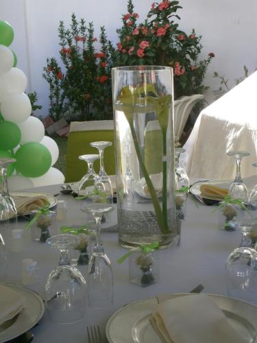 a table with a glass vase with flowers in it at Whispering Bamboo Cove Resort in Belfast
