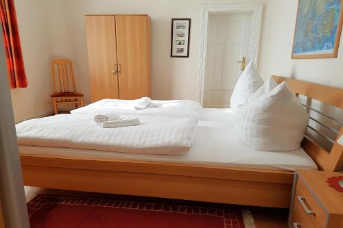 a bed with white sheets and pillows on it at Bellevue-App-05 in Ahlbeck