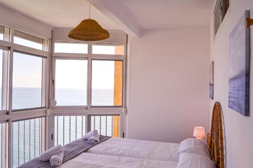 a bedroom with a bed and a large window at Beach Mijas Apartment Málaga in Mijas Costa