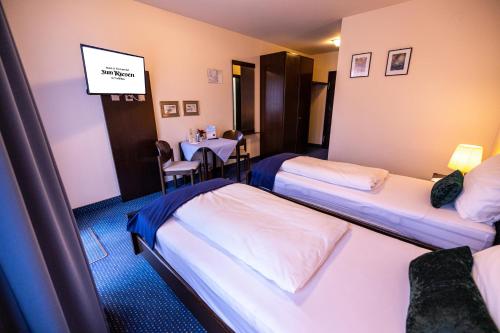 a hotel room with two beds and a table at Hotel & Restaurant Zum Riesen in Walldürn