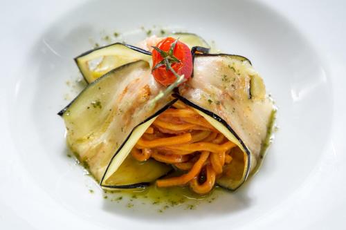 a plate of food with vegetables on a white plate at Hotel Capannelle Roma in Rome
