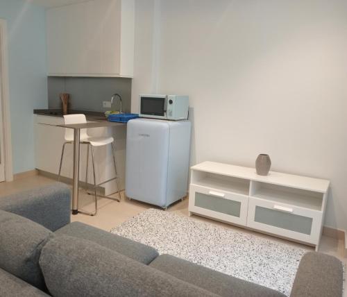 a living room with a couch and a kitchen at Apartamentos Tras dos Fornos in Chantada