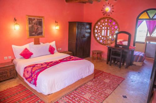 a bedroom with a bed and a desk in a room at Taloute Ecolodge in Skoura