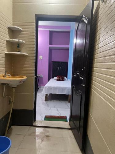 a bathroom with a purple room with a bed at Riru girlstay in Patna