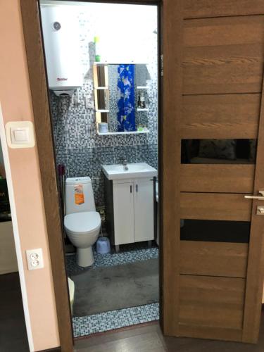 a bathroom with a toilet and a sink at Квартира ЛЮКС in Balqash