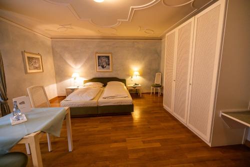 a bedroom with a bed and a table and chairs at Hotel & Restaurant Zum Riesen in Walldürn
