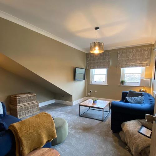 a living room with blue couches and a table at The Spa Hotel in Saltburn-by-the-Sea
