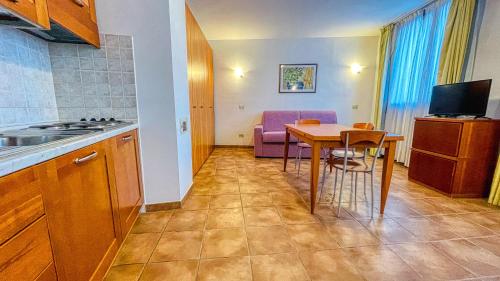 a kitchen and dining room with a table and purple chairs at Appartamento Smith Erbaluce - Affitti Brevi Italia in Bardonecchia