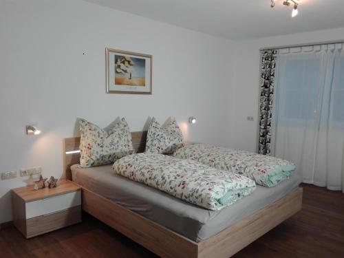 1 dormitorio con cama y mesita de noche con cama sidx sidx en Appartement Juffinger, en Thiersee