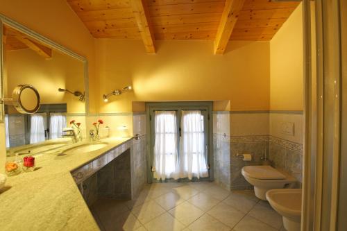 a bathroom with a sink and a toilet and a mirror at Palazzo Del Vicerè in Lezzeno