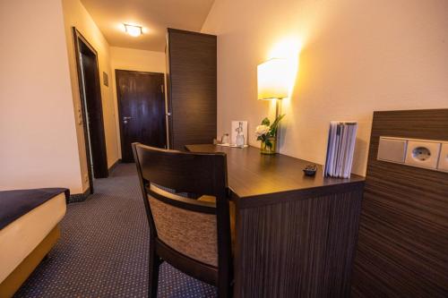 een kamer met een bureau in een hotelkamer bij Hotel & Restaurant Zum Riesen in Walldürn