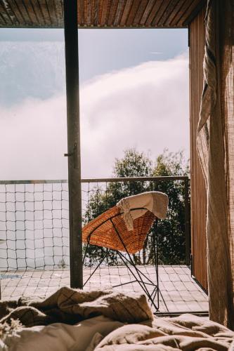 a chair on a balcony with a view of the ocean at TheVagar Countryhouse in Belmonte