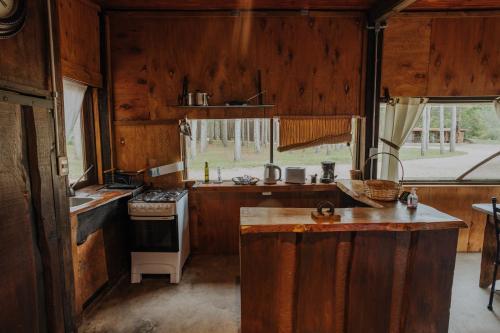 a kitchen with wooden cabinets and a stove top oven at Cabañas en el Bosque a 5 minutos del mar - Estancia CH in Punta del Este
