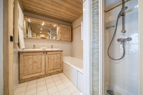 a bathroom with a tub and a sink and a shower at Les Balcons de Pralong Courchevel 1850 - by EMERALD STAY in Courchevel