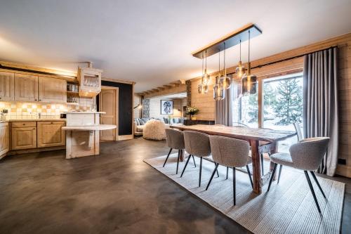 une cuisine et une salle à manger avec une table et des chaises dans l'établissement Les Balcons de Pralong Courchevel 1850 - by EMERALD STAY, à Courchevel