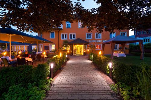a walkway in front of a building with lights at Ganter Hotel & Restaurant Mohren in Reichenau
