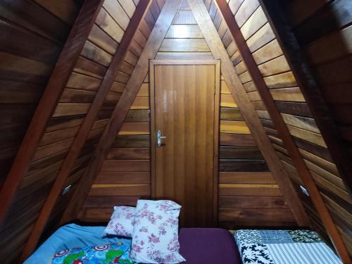 Habitación pequeña con cama y puerta en Cantinho da Vandisa, en Ilhabela