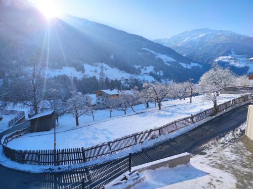a snow covered hill with a fence and trees at Apartment FeWo Anna by Interhome in Fliess