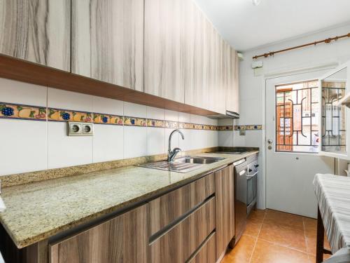 eine Küche mit Holzschränken und einem Waschbecken in der Unterkunft Apartment Mar Menor by Interhome in Los Alcázares