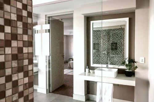 a bathroom with a sink and a mirror at The Waterfront Penthouse in Hermanus