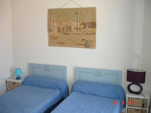 a bedroom with two beds and a picture on the wall at L' Ecume de Mer in Châtelaillon-Plage
