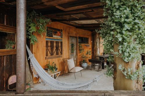 a porch with a hammock in a house at Cabañas en el Bosque a 5 minutos del mar - Estancia CH in Punta del Este