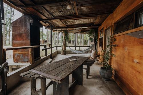 a wooden table in a room with a hammock at Cabañas en el Bosque a 5 minutos del mar - Estancia CH in Punta del Este