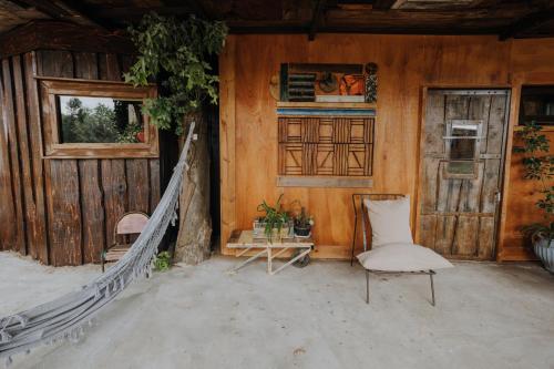 a room with a hammock and a chair in a house at Cabañas en el Bosque a 5 minutos del mar - Estancia CH in Punta del Este