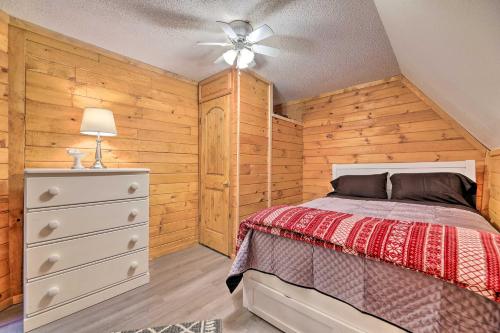 Cozy Yatesville Lake Cabin Rental in Louisa! في Louisa: غرفة نوم بسرير ومروحة سقف