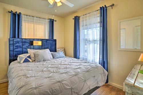 a bedroom with a large bed with blue curtains at Vibrant Prescott Cottage with Private Backyard! in Prescott