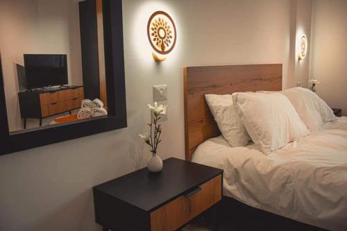 a bedroom with a bed with a table and a mirror at Villa Saar in Mas'ade