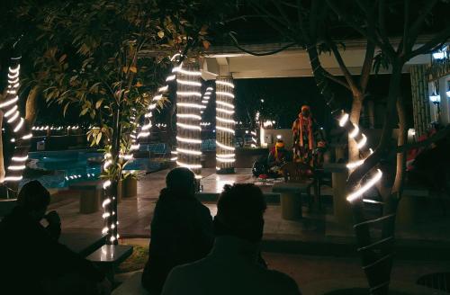 a group of people sitting in a room with lights at CHARULATA RESIDENCY in Bolpur