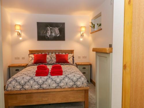 - une chambre avec un lit doté d'oreillers rouges dans l'établissement The Nest, à Buxton